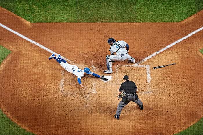 Dodgers’ Mookie Betts slides headfirst into home plate ahead of a tag from Rays catcher Mike Zunino during the 2020 World Series